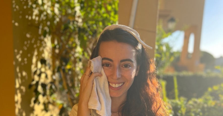 Pilar con una toalla y un bol de agua en su ritual facial